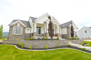 View of front of house with stone siding, board and batten siding, and a front lawn