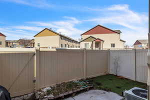 View of yard featuring central air condition unit, a residential view, a fenced backyard, and a gate