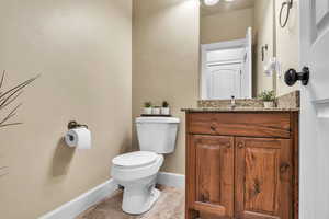 Bathroom featuring tile patterned floors, toilet, vanity, and baseboards