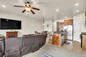 Living room with light tile patterned flooring, recessed lighting, a fireplace, and a ceiling fan