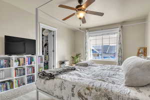 Carpeted bedroom featuring ceiling fan