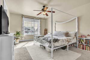 Carpeted bedroom with a ceiling fan