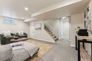 Living area with recessed lighting, stairway, carpet flooring, and baseboards