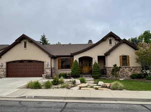 Ranch-style house featuring driveway, stone siding, a chimney, stucco siding, and a garage