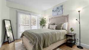 Bedroom with access to exterior, wood finished floors, and baseboards
