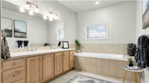 Full bathroom featuring a sink, a bath, double vanity, and tile patterned flooring