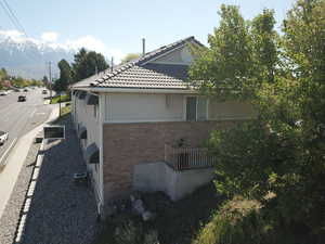 View of home's exterior with brick siding, central AC unit, stucco siding, and a tiled roof