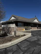 Single story home with brick siding, covered porch, and a tile roof