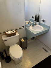 Half bathroom with tile patterned floors, visible vents, toilet, and a sink