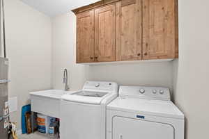 Washroom featuring cabinet space and independent washer and dryer