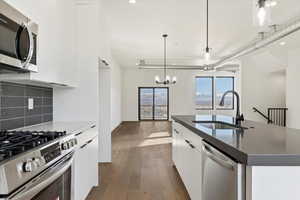 Kitchen with white cabinets, modern cabinets, appliances with stainless steel finishes, and a sink