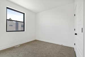 Unfurnished room with carpet flooring, baseboards, and visible vents