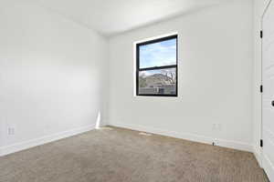 Carpeted empty room with baseboards
