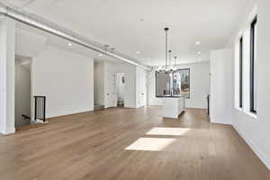 Unfurnished living room with a sink, light wood-style flooring, and recessed lighting