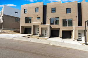 Exterior space with driveway, brick siding, and an attached garage