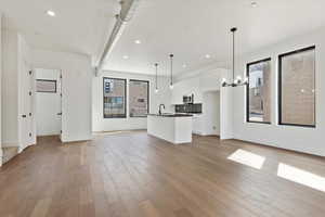 Unfurnished living room featuring recessed lighting, light wood-style flooring, and a sink