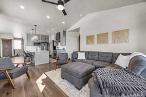 Living area featuring lofted ceiling, recessed lighting, a ceiling fan, and light wood finished floors