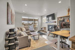 Carpeted living area with visible vents, recessed lighting, and a fireplace