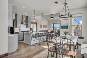 Dining room featuring recessed lighting, ceiling fan with notable chandelier, light wood-type flooring, and lofted ceiling