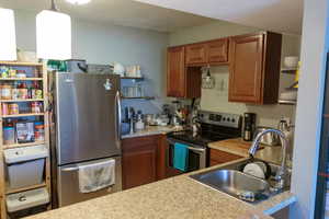 Kitchen with a sink, stainless steel appliances, wood cabinets, and granite countertops