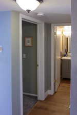 Hallway with light wood-type flooring, baseboards, and a sink