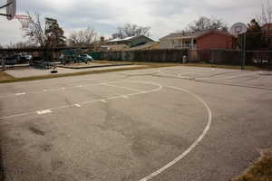 View of basketball court with community basketball court, fence, and playground community