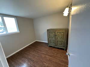 Interior space featuring dark wood-type flooring and baseboards