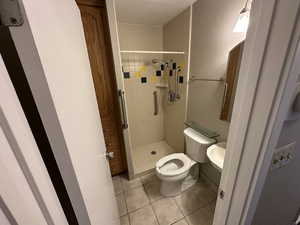 Bathroom with a shower stall and tile patterned flooring