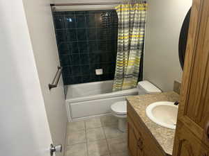 Bathroom with tile patterned floors, shower / tub combo with curtain, and vanity