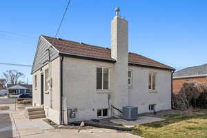 Rear view of house featuring central air conditioning unit, fence, newer roof, and painted brick siding.