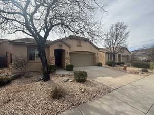 View of front of home featuring stone siding, stucco siding, concrete driveway, and a garage