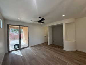 Unfurnished bedroom featuring baseboards, a textured ceiling, wood finished floors, and access to outside