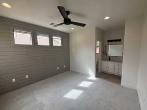 Unfurnished bedroom featuring recessed lighting, visible vents, light colored carpet, and wood walls