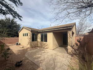 Rear view of house with central AC unit, a patio area, a fenced backyard, and stucco siding