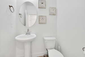 Half bathroom featuring toilet and baseboards