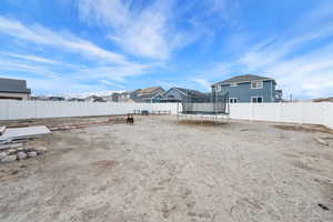 View of yard with a fenced backyard, a residential view, and a trampoline