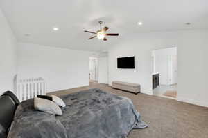 Bedroom featuring a ceiling fan, visible vents, baseboards, lofted ceiling, and light carpet