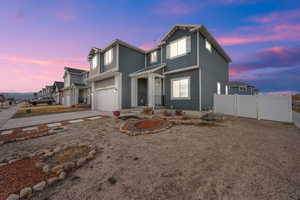 Traditional-style home featuring concrete driveway, a gate, fence, and a garage