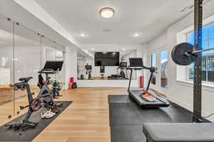 Workout area with visible vents, wood finished floors, baseboards, and french doors