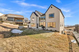 Rear view of house featuring fence and stucco siding