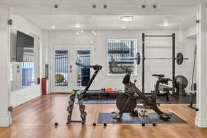 Workout room with french doors, baseboards, and wood finished floors