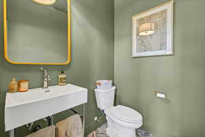 Bathroom with toilet, baseboards, and a sink