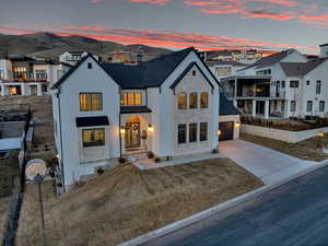 View of front facade with stone siding, a garage, a residential view, and driveway