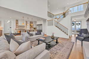 Living room featuring stairs, recessed lighting, french doors, and light wood finished floors