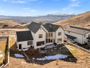 Rear view of house featuring a mountain view, a fenced backyard, and stucco siding