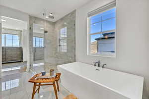 Bathroom with a stall shower and a freestanding bath