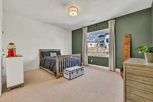 Bedroom featuring visible vents, a textured ceiling, baseboards, and carpet floors