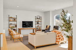 Living area featuring carpet flooring, recessed lighting, and visible vents