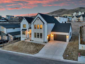 View of front facade with a garage, fence, a residential view, and stone siding