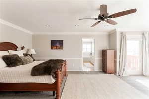 Primary bedroom with light carpet, crown molding, and ensuite bathroom.